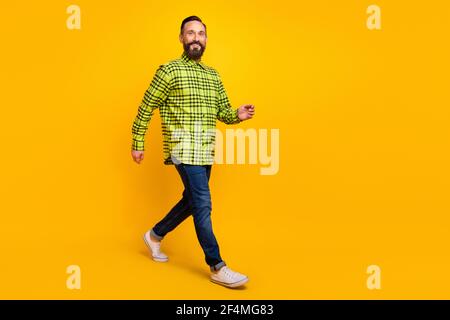 Volle Länge Profil Seite Foto von reifen Mann glücklich positiv Smile go Walk tragen lässiges Outfit isoliert über gelbe Farbe Hintergrund Stockfoto