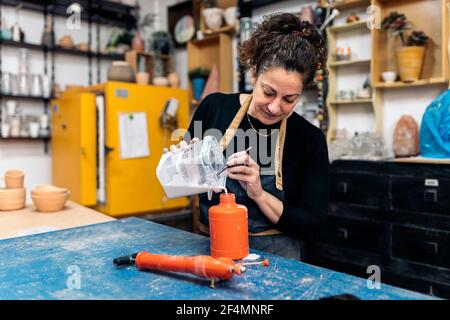 Stock Foto von konzentrierten Frau Vorbereitung spezielle Mischung für Keramik-Klasse. Stockfoto