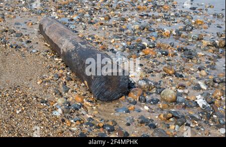 Ein großes Stück rundes Holz auf einem ausgewaschen North Norfolk Beach Stockfoto