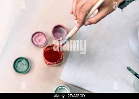 Stock Foto von nicht erkannten Person mit Pinsel während der Töpferklasse. Stockfoto