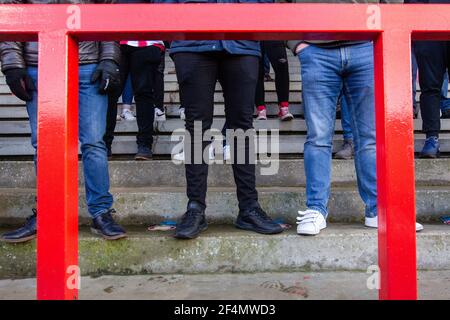 Fans und Zuschauer beobachten Fußballspiele der unteren Liga während der Coronavirus-Pandemie Covid-19 in England, Großbritannien. Tragen von Gesichtsbezügen und Gesichtsmasken. Stockfoto