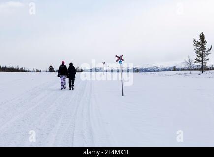 SCANDES, SCHWEDEN AM 28. APRIL 2012. Blick auf Schneemobilstrecken, auf denen zwei unbekannte Frauen spazieren gehen. Redaktionelle Verwendung. Stockfoto