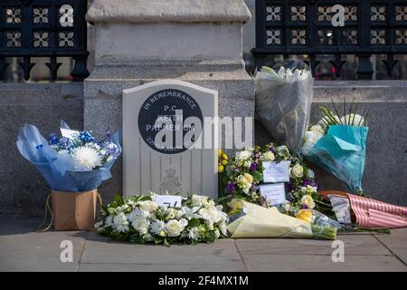 Blumengebete, die um das Denkmal zu Ehren von PC Keith Palmer, der während des Terroranschlags in Westminster getötet wurde, vor dem Palace of Westminster, London, am vierten Jahrestag des Angriffs platziert wurden. Bilddatum: Montag, 22. März 2021. Stockfoto