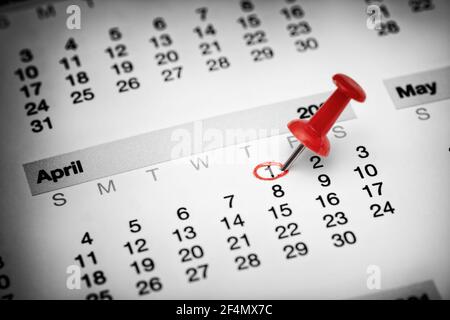 Eine rote Nadel auf dem ersten April auf einem Kalender. Nahaufnahme. Stockfoto
