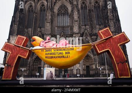 Vertreter der Opfer protestieren gegen die zögerliche Offenlegung von Missbrauchsfällen durch kirchenbeamte mit einer Skulptur des Künstlers Jacques Tilly in Vorderseite des t Stockfoto