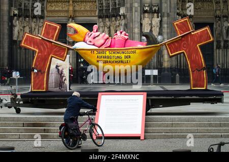 Vertreter der Opfer protestieren gegen die zögerliche Offenlegung von Missbrauchsfällen durch kirchenbeamte mit einer Skulptur des Künstlers Jacques Tilly in Vorderseite des t Stockfoto