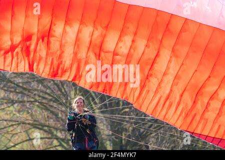 Die Gleitschirmfliegerin Karen praktiziert im Brockwell Park im Süden Londons, während die Menschen das warme Frühlingswetter genießen. Bilddatum: Montag, 22. März 2021. Stockfoto