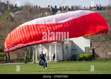 Die Gleitschirmfliegerin Karen praktiziert im Brockwell Park im Süden Londons, während die Menschen das warme Frühlingswetter genießen. Bilddatum: Montag, 22. März 2021. Stockfoto