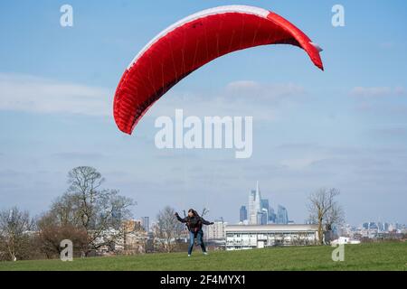 Die Gleitschirmfliegerin Karen praktiziert im Brockwell Park im Süden Londons, während die Menschen das warme Frühlingswetter genießen. Bilddatum: Montag, 22. März 2021. Stockfoto