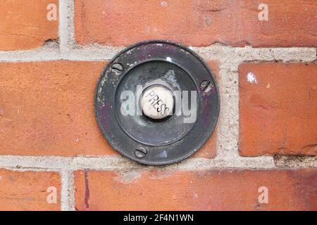 Altmodische Türglocke in Mauerwerk mit dem Wort Presse Stockfoto