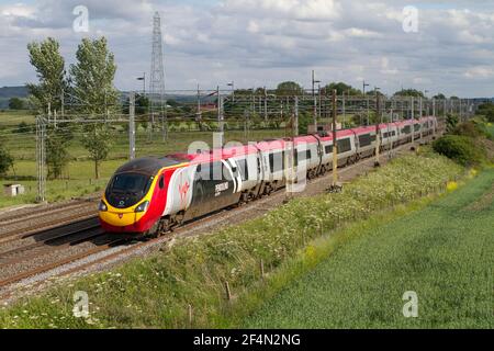 Eine elektrische Einheit der Klasse 390 Pendolino Nummer 390034 in einer speziellen Alstom-Lackierung, die einen nordwärts führenden Virgin West Coast-Dienst arbeitet. Stockfoto