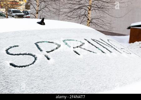 Die Inschrift auf der schneebedeckten Heckscheibe des Autos Frühling an einem hellen sonnigen Tag. Nahaufnahme Stockfoto