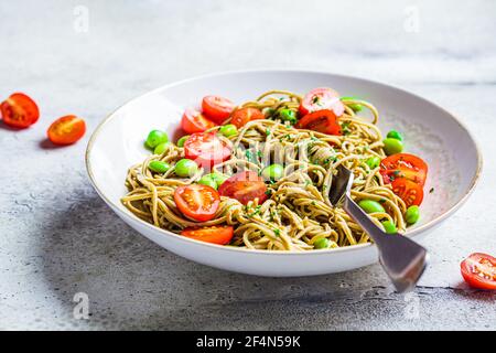 Grüne vegane edamame Pasta mit Tomaten und Bohnen. Pflanzliches Diät-Konzept. Stockfoto