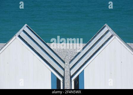 Symmetrie, zwei blau weiße Holzhütten am Strand von Yport, Normandie Stockfoto