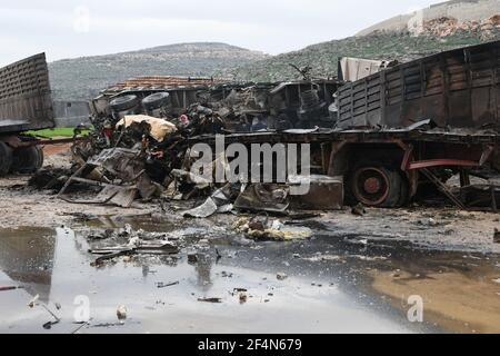 Idlib - Syrien, Grenzübergang Bab al-Hawa, 22. März 2021, Zivilisten inspizieren ihr Eigentum, das nach einem russischen Luftangriff verbrannt wurde, der eine Garage für Lastwagen in der Nähe des Grenzübergangs Bab al-Hawa zur Türkei anvisierte, der von der syrischen Opposition kontrolliert wird.Quelle: Rami Alsayed/Alamy Live News Stockfoto