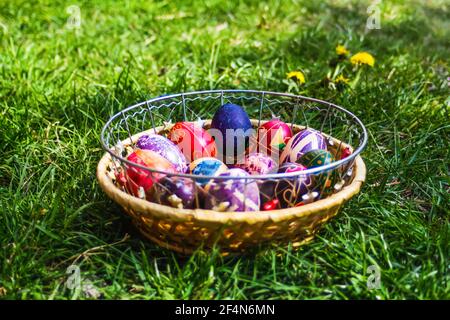 Defokussieren Sie bunte ostereier. Dekoriert pysanka und krashanka. Holzkorb Mit Ostereiern Im Grünen Gras. Nahaufnahme. Festlich. Traditionell. Stockfoto