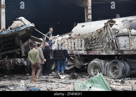 Idlib - Syrien, Grenzübergang Bab al-Hawa, 22. März 2021, Zivilisten inspizieren ihr Eigentum, das nach einem russischen Luftangriff verbrannt wurde, der eine Garage für Lastwagen in der Nähe des Grenzübergangs Bab al-Hawa zur Türkei anvisierte, der von der syrischen Opposition kontrolliert wird.Quelle: Rami Alsayed/Alamy Live News Stockfoto