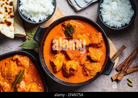 Chicken Tikka Masala in einer würzigen Sauce mit Reis und Chapati Brot, dunkler Hintergrund. Konzept der indischen Küche. Stockfoto