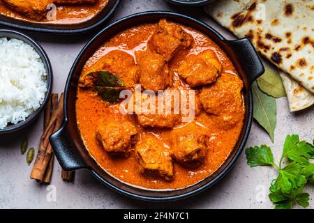 Chicken Tikka Masala in einer würzigen Sauce mit Reis und Chapati Brot, dunkler Hintergrund. Konzept der indischen Küche. Stockfoto