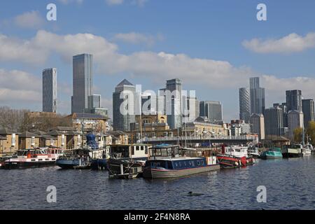 Hausboote in Greenland Dock, Rotherhithe, London, Vereinigtes Königreich. Ein Teil der alten Surrey Docks wurde 1980s neu entwickelt. Canary Wharf Türme im Hintergrund. Stockfoto