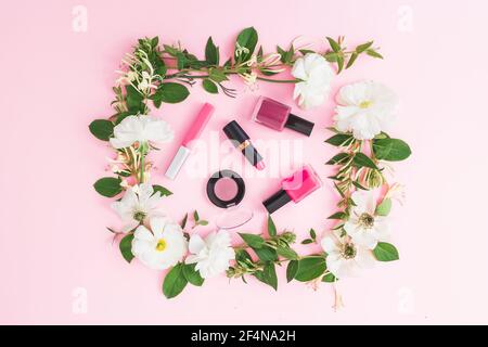 Modischer Beauty-Schreibtisch mit Kosmetik und Blumen auf weißem Hintergrund. Flach liegend, Draufsicht. Stockfoto