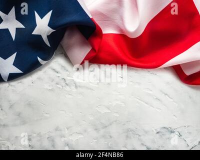 Amerikanische Flagge liegt auf einem leeren Tisch. Platz für Ihre Inschrift. Wunderschöne Karte. Nahaufnahme, Ansicht von oben. Nationales Urlaubskonzept. Herzlichen Glückwunsch Stockfoto