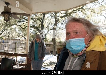 Austin, TX USA 20. Feb 2021: Obdachlose Veteranen kommen für ihre erste Nacht in einem privat geführten nüchternen Haus an, nachdem sie eine Woche in einem kirchengeführten Wärmerehelort während Austins kürzlicher schwerer Winterwetterlage verbracht haben. Kirchenmitglieder arrangierten die neuen Unterkünfte, nachdem beide Männer um Hilfe für ihren Alkoholismus gebeten hatten. Stockfoto