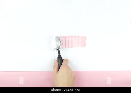 Eislöffel in der Hand reißt ein Stück weißes Papier auf einem rosa Hintergrund. Minimalkonzept. Flach liegend, Draufsicht, Kopierbereich Stockfoto