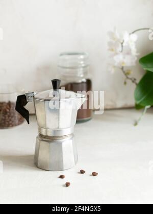 Das Konzept der Kaffee in einer Küche zu Hause. Die Geysir-Kaffeemaschine befindet sich auf dem Tisch neben den Kaffeekannen. Vertikale Ausrichtung. Speicherplatz kopieren. Stockfoto