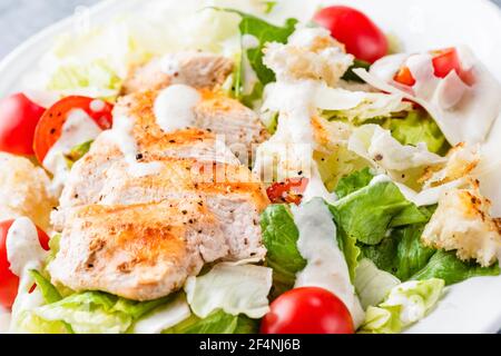 Nahaufnahme Ansicht Caesar Salat mit Huhn, Sauce und Kirschtomaten Stockfoto