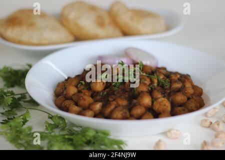 Würzige Kichererbsen-Soße mit gebratenem indischem Fladenbrot. Lokal bekannt als Chole puri. Aufnahme auf weißem Hintergrund Stockfoto