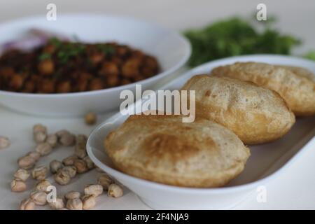 Flauschige Vollkorn gebratenes indisches Fladenbrot, serviert zusammen mit würziger Kichererbsen-Soße. Lokal bekannt als Chole puri. Aufnahme auf weißem Hintergrund Stockfoto