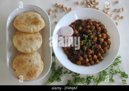 Flauschige Vollkorn gebratenes indisches Fladenbrot, serviert zusammen mit würziger Kichererbsen-Soße. Lokal bekannt als Chole puri. Aufnahme auf weißem Hintergrund Stockfoto