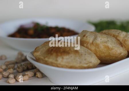 Flauschige Vollkorn gebratenes indisches Fladenbrot, serviert zusammen mit würziger Kichererbsen-Soße. Lokal bekannt als Chole puri. Aufnahme auf weißem Hintergrund Stockfoto