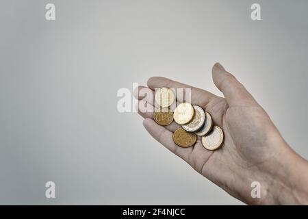 Münzen in der Hand. Konzept von Almosen und Spenden. Geringe Einsparungen. Ausgaben und Einnahmen. Stockfoto