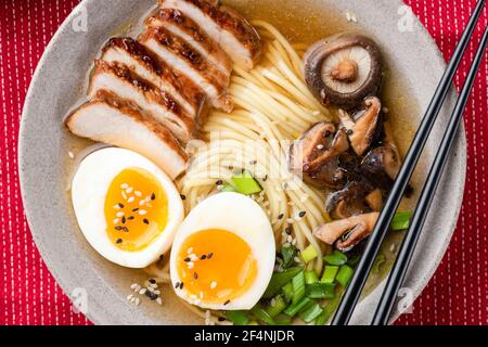 Schüssel mit Ramen Nudelsuppe mit Huhn, Shiitake und Ei, Nahaufnahme Stockfoto