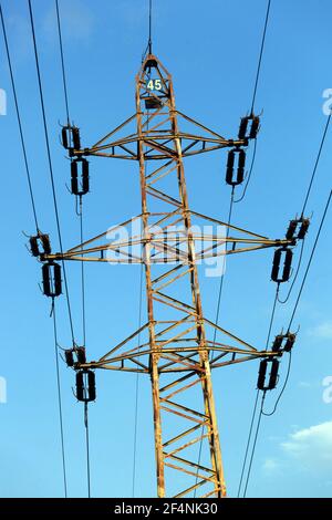 Ein elektrischer Mast gegen blauen Himmel Stockfoto