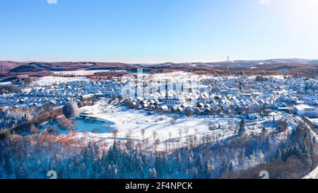 Luftaufnahme der Stadt Winterberg im Hochsauerland. Schneebedeckte Häuser und Geschäfte. Wald und Hügel umrahmen die Stadt. Stockfoto