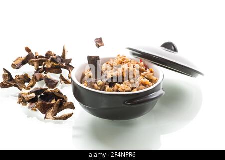 Gekochter Buchweizen mit Bio-Waldpilzen in einer Keramik Schüssel isoliert auf weißem Hintergrund Stockfoto
