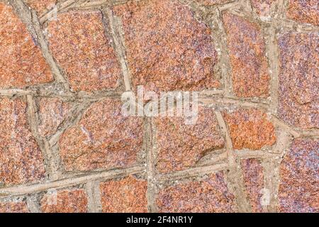 Rote und braune Stein Kopfsteinpflaster Wand Textur Hintergrund. Stockfoto