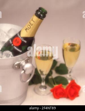 Champagner von Moët & Chandon im Eiskübel mit roten Rosen und Kristallgläsern, Greater London, England, Vereinigtes Königreich Stockfoto