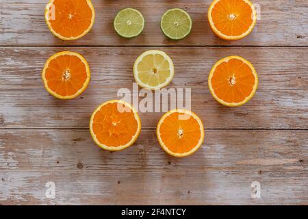 Orangen, Limetten und Zitronen Rutschen auf Holztisch Blick von oben. Wunderschön Hintergrund mit frischem Obst halb geschnitten.gesunde Ernährung Vitamin C.Sommer tropic Stockfoto