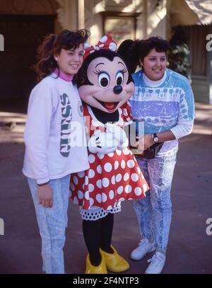 Junge Frauen mit Minnie-Charakter, Fantasyland, Disneyland, Anaheim, Kalifornien, Vereinigte Staaten von Amerika Stockfoto