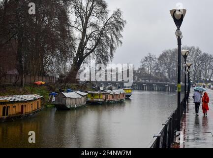 Srinagar, Indien. März 2021, 22nd. Pendler laufen unter einem Regenschirm während der Regenfälle in Srinagar.die meteorologische Abteilung (MET) hat vier Tage nass Zauber über das Kaschmir-Tal von März 21 bis März 24 mit der großen Intensität der Vorhersage erwartet am 22. März und 23. März vorhergesagt. (Foto von Saqib Majeed/SOPA Images/Sipa USA) Quelle: SIPA USA/Alamy Live News Stockfoto