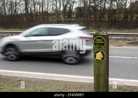 Öffentliches Wanderwegschild, wo der Weg die Straße A46 kreuzt, Hampton Magna, Warwickshire, Großbritannien Stockfoto