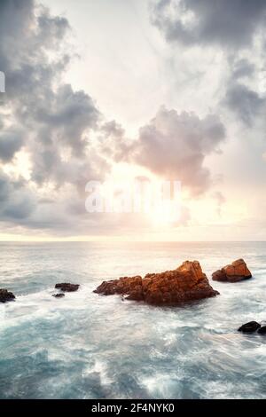 Felsen im Meer bei Sonnenuntergang, Langzeitbelichtung Bild. Stockfoto