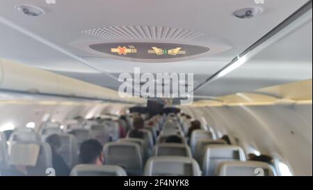 Sicherheitsgurt und Rauchverbotsschild an einem Passagierflugzeug anlegen Stockfoto