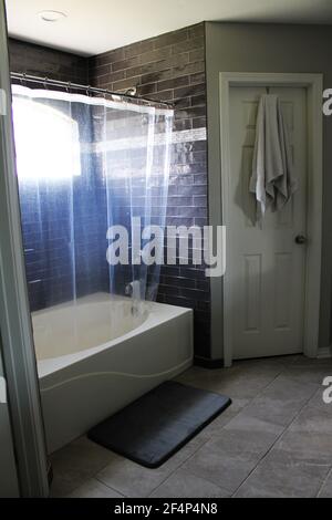Mein geräumiges Badezimmer verfügt über eine große Badewannen-/Duschkombination Und einen begehbaren Schrank Stockfoto
