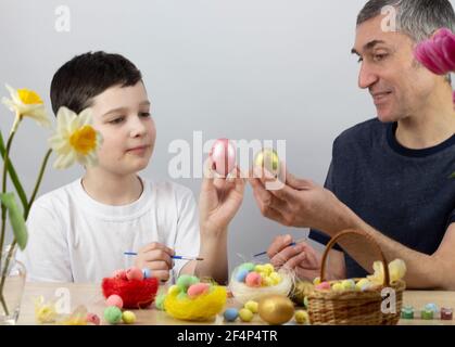 Ostereier. Frohe Ostern Karte. Mehrfarbige Ostereier. Ostern. Ostereier auf weißem Holzhintergrund. Für Text platzieren Stockfoto