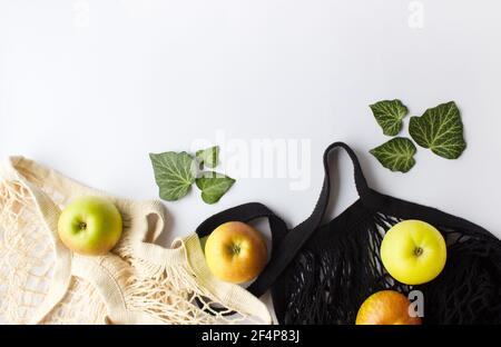 Mesh-Einkaufstasche mit grünen Äpfeln auf weißem Hintergrund. Zero Waste Shopping-Konzept. Stockfoto